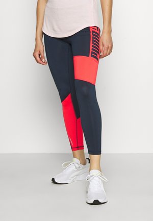 Leggings de sport bleu marine et rose vif avec un bloc de couleurs géométrique, fabriqués en matériau extensible, présentant un logo sur le côté et des accents réfléchissants.