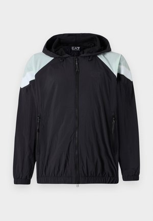 Casaco preto leve com capuz, apresentando acentos em verde menta nos ombros e detalhes em branco listrado. Inclui bolsos com zíper e punhos elásticos.