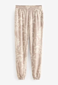 Světlé béžové teplákové kalhoty s elastickým pasem a manžetami, zdobené bílým květinovým vzorem a vířivými motivy po celé látce.