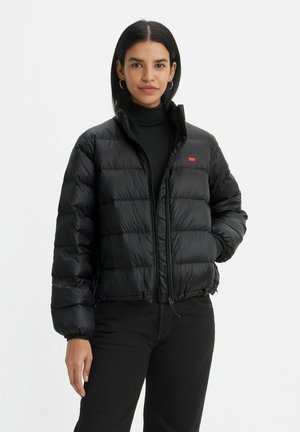Giacca a vento nera, design trapuntato con colletto alto, zip frontale e accento del logo rosso. Realizzata in un materiale lucido con una consistenza liscia.