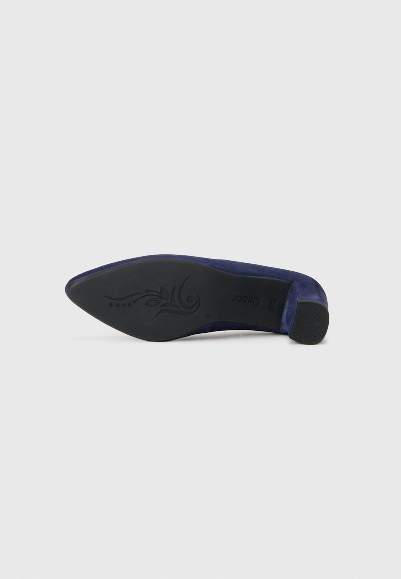 Chaussure à talon haut marine vue par le dessous, présentant un bout pointu et une semelle texturée avec un design décoratif et le logo de la marque.