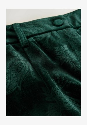 Roheline sametkangas paisley mustriga, koos nööbiga sulgemise ja tekstureeritud pinnaga. Suurendatud vaade kanga detailidele.