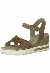 Brown leather wedge sandals with cut-out floral design, ankle strap with buckle, and layered textured sole in white and cork.