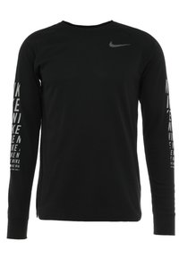 Schwarzes Langarmshirt aus weichem Stoff, mit rundem Ausschnitt, einem kleinen grauen Nike-Logo auf der Brust und Text entlang der Ärmel.