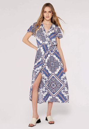 Maxikleid aus weißem Stoff mit blauen und roten Paisleymustern. Es hat kurze Ärmel, ein Wickeldesign und einen oberschenkelhohen Schlitz.