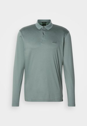 Polo à manches longues en tissu vert pâle. Présente un col, une patte de boutonnage à trois boutons et un logo brodé sur la poitrine.