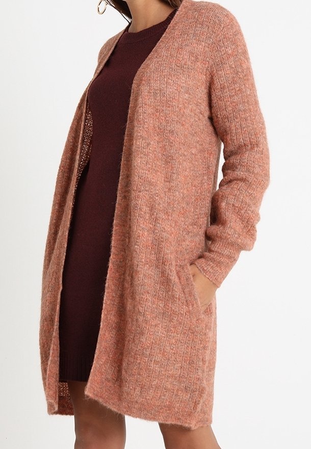 Dlouhý cardigan otevřeného střihu z měkkého, texturovaného pleteného materiálu, v teplé broskvové barvě, s ribbovaným designem a dvěma bočními kapsami.