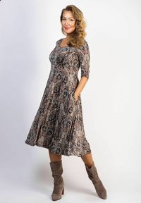 Ein fließendes, knielanges Kleid mit einem Paisley-Muster in dunklen Farben, aus weichem Stoff gefertigt; verfügt über Dreiviertelärmel und seitliche Taschen.