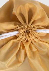 Bolsa amarilla con cordón, hecha de tela suave y resistente al agua, con parte superior fruncida y cuerdas trenzadas blancas como cierre.