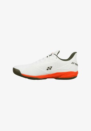 Chaussure de sport basse blanche avec une semelle intermédiaire orange, une semelle noire et un logo Yonex noir sur le côté et le talon.