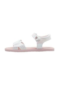 Sandalias blancas con un diseño de tira texturizada y una suela rosa. Incluyen un cierre de velcro y un acento de corazón en la tira.