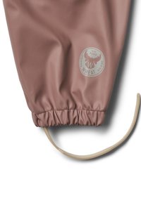 Zbliżenie na rękaw z tkaniny w kolorze przydymionego różu z elastycznym mankietem i beżowym regulowanym paskiem, z okrągłym logo z łosiem i tekstem "Danish Wheat Design est 2002".
