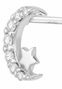 Orecchino a forma di mezzaluna argentata con sette pietre chiare incastonate, dotato di un accento a stella tridimensionale. Finitura metallica liscia e lucente.
