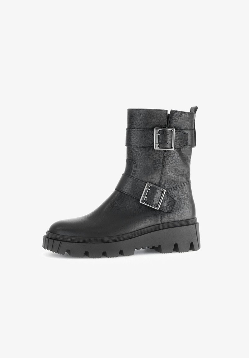 Bottine en cuir noir avec semelle crantée épaisse et deux boucles argentées réglables sur la tige pour un look robuste et stylé.