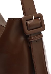 Borsa a mano in pelle marrone con finitura liscia. Caratterizzata da una tracolla spessa con una fibbia rettangolare, che mette in evidenza i dettagli delle cuciture di alta qualità.