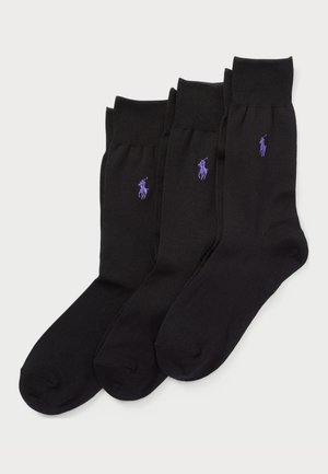 Ensemble de chaussettes noires comprenant trois paires avec des bords côtelés et de petites accents de logo violet. Fabriqué en tissu lisse et extensible.