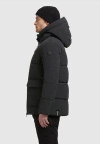 Schwarze Daunenjacke mit Kapuze, ausgestattet mit einem gesteppten Design, Seitentaschen und einem runden Logopatch am linken Ärmel.