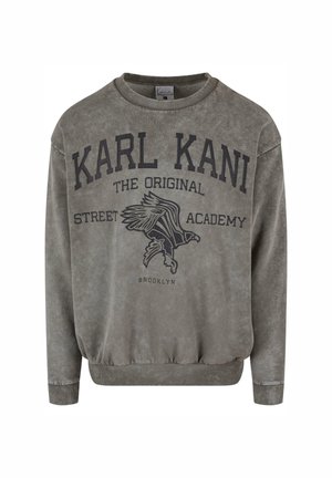 Grau Sweatshirt mit Rundhalsausschnitt, gerippten Bündchen und Saum. Mit "KARL KANI" und einem grafischen Adlerdesign in dunkler Schrift.