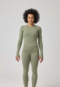 Langärmliges, eng anliegendes Sportoberteil und Leggings in Olivgrün, aus dehnbarem, glattem Material, mit Daumenlöchern und nahtlosem Design.