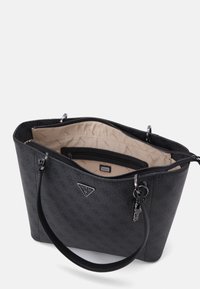 Sac cabas noir de Guess avec motif logo, double anses, et intérieur beige comprenant une poche zippée et une doublure avec le logo Guess.