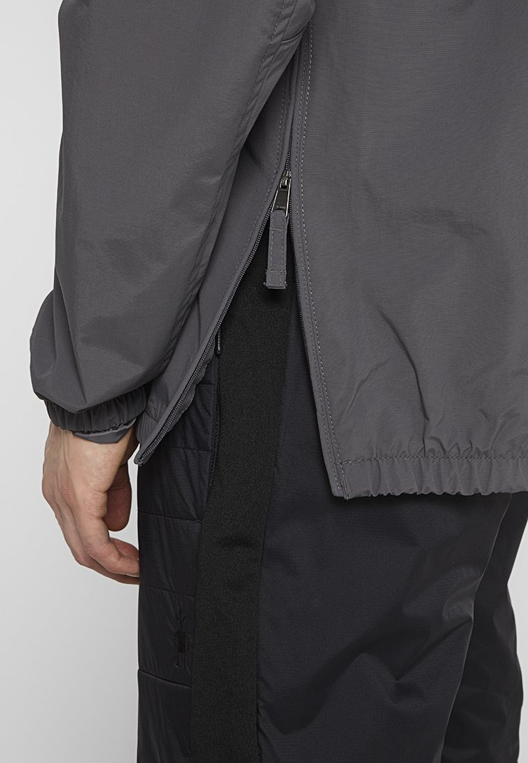 Szary kurtka z elastycznymi mankietami i dołem, z suwakową kieszenią boczną. Nosi się ją na czarnych spodni z ociepleniem o smukłym kroju.