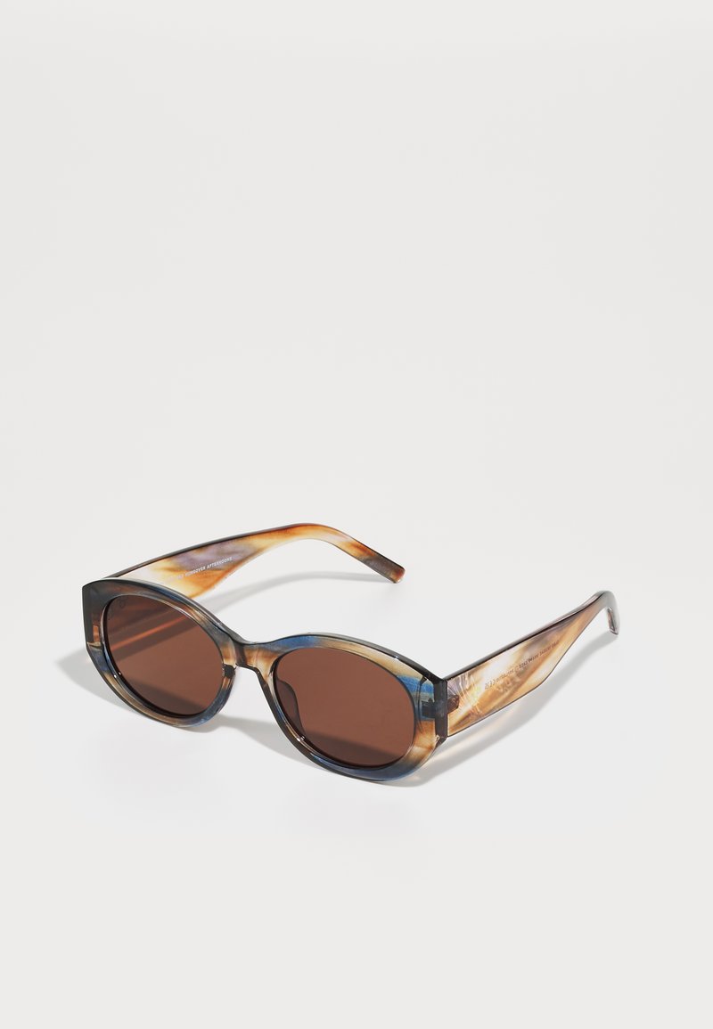 Lunettes de soleil teintées marron avec une large monture ovale, ornées d'un motif marbré translucide bleu et marron, texture lisse et branches élégantes.