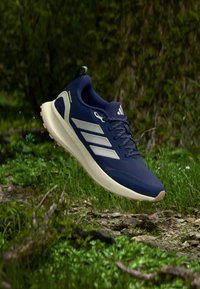 Navy blue athletic shoes with white accents, mesh upper, and rubber sole. Features three stripes logo and a textured toe design.