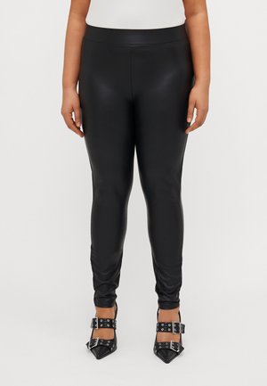 Black faux leather leggings featuring a smooth texture, slim fit, and a high waistband. Paired with pointed-toe black heels with buckles.