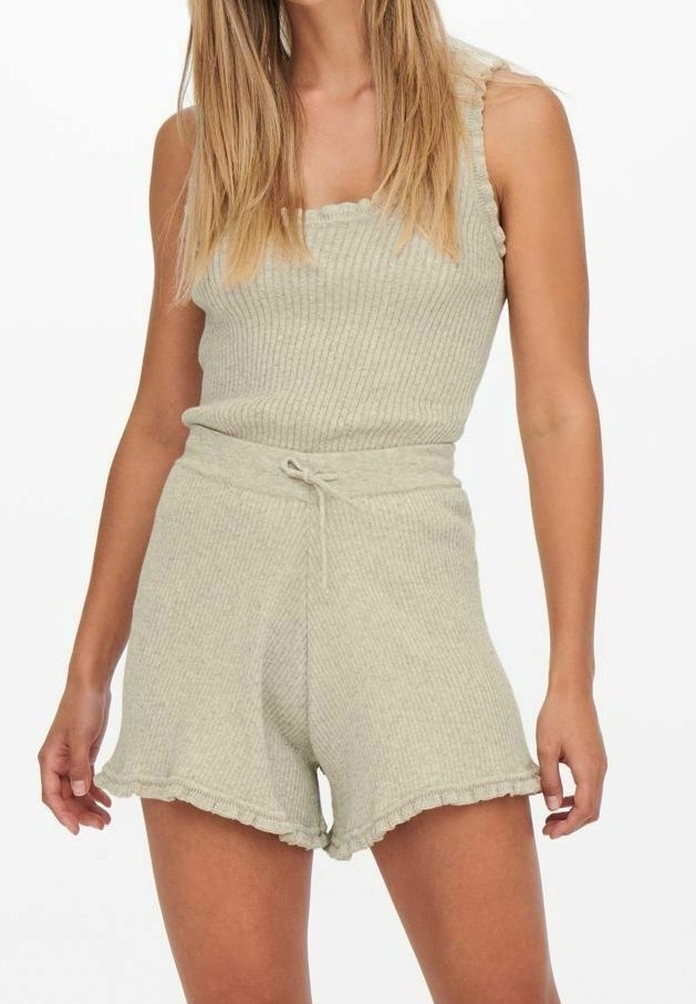 Conjunto de camiseta de tirantes y pantalones cortos en gris claro con textura acanalada. Tela texturizada, forma ajustada, con bordes con volantes y cintura ajustable con cordón.