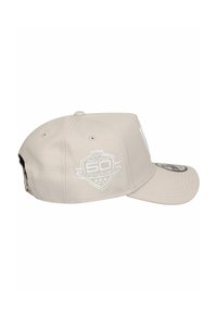 Beige Baseball-Cap mit flacher Krempe, versehen mit gesticktem Logo und Datumsangaben; aus Stoff mit glatter Textur.