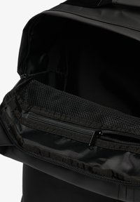 Zwarte rugzak interieur met een mesh ritszak, gladde voering en een gestructureerde vorm met verstevigde randen.