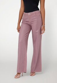 Vysoké, svetloružové široké nohavice s textúrovaným vzorom, obsahujúce predné vrecká, pútka na opasok a zapínanie na gombík.