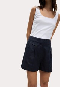 Shorts en lin bleu marine au toucher lisse, dotés d'une taille plate, de poches latérales et d'un bouton unique à l'avant.