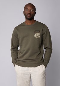 Olijfgroen sweatshirt met een ronde halslijn en geribbelde mouwen, met een grafisch ontwerp op de linkerborst met de tekst "No Pain No Gain."