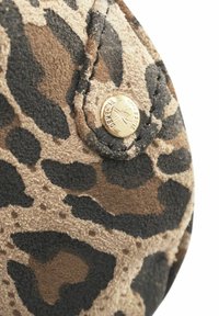 Leopardprint ruskind med en blød tekstur, der har en guldfarvet metalknap med præget logo-detalje. Rund form med kontrasterende farver.