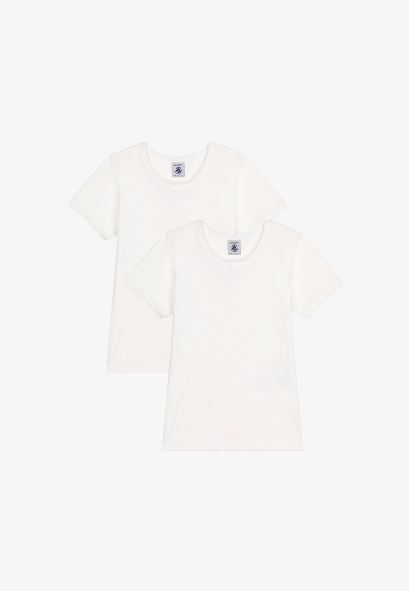 Dvě jednoduchá bílá bavlněná trička s krátkým rukávem, jedno mírně za druhým, zepředu s kulatými výstřihy a štítky uvnitř límečků.
