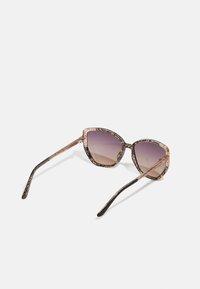 Cat-eye sunglasses with patterned gold and black plastic frame and gradient purple lenses. Slim black temples extend from the frame.