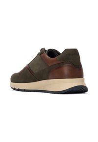 Zapatillas de color verde oliva con detalles en cuero marrón, suela gruesa beige y gamuza texturizada. Forma redondeada con talón acolchado y suela de goma.