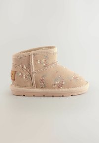 Stivaletto beige realizzato in morbido tessuto con motivi floreali nei toni rosa e blu. Presenta una cucitura a vista e una suola in gomma testurizzata.