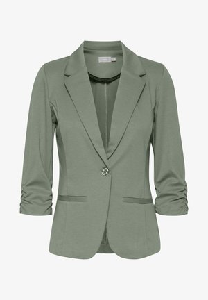 Zöld, rugalmas blézer, kivágott gallérral, egy gombos zárással és ráncolt háromnegyedes ujjakkal. Két elülső zsebe van.