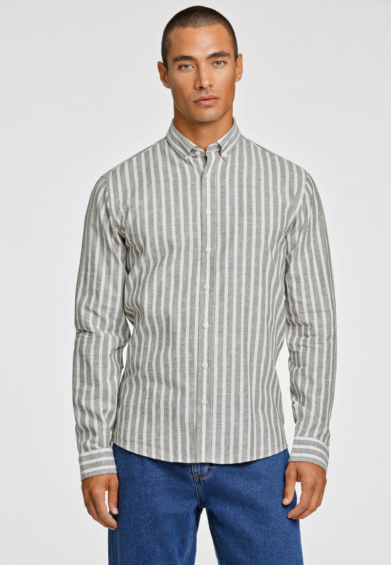 Grijs en wit gestreepte overhemden met lange mouwen, voorzien van een kraag en rechte zoom, gecombineerd met blauwe denim broek.