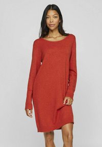Abito rosso a maglia con scollatura ampia, maniche lunghe e polsini a costine. Il tessuto sembra morbido con una leggera trama e una vestibilità comoda.