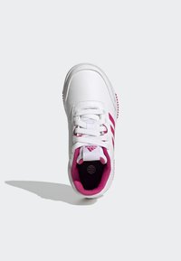 Baskets blanches avec des accents roses, dotées d'une tige synthétique lisse, de lacets et d'une semelle antidérapante texturée.