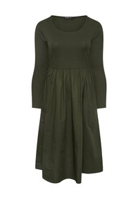 Długa, oliwkowozielona sukienka z długim rękawem, dopasowanym, prążkowanym gorsetem, wycięciem w kształcie łódki i marszczoną spódnicą sięgającą do połowy łydki.