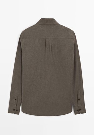 Camicia marrone a maniche lunghe con colletto, caratterizzata da un'imbastitura posteriore e polsini con bottoni, realizzata in tessuto strutturato con un motivo sottile.