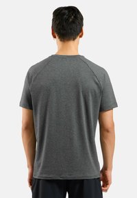 Grijze sportieve t-shirt met korte raglanmouwen, zachte textuur en een ronde halslijn. De achterkant laat een gladde pasvorm en minimalistisch ontwerp zien.