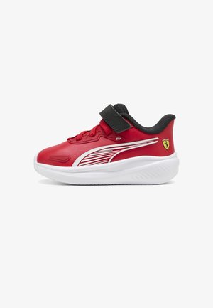 Rød børnesneaker med hvid sål, sort krave, røde snørebånd, sort velcrorem, hvidt stribedesign og gult Ferrari-logo på hælen.