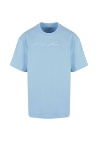 T-shirt en coton bleu clair avec un col rond et des manches courtes. Il a un logo en script blanc imprimé sur le devant.