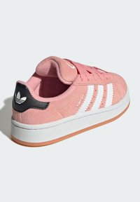 Pink suede sneaker with white stripes and black heel accent. Features round toe, lace closure, and gum rubber sole.