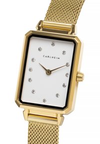 Reloj rectangular dorado con esfera blanca, marcadores de hora de cristal y correa de malla. Presenta un borde negro y una corona en el lateral.